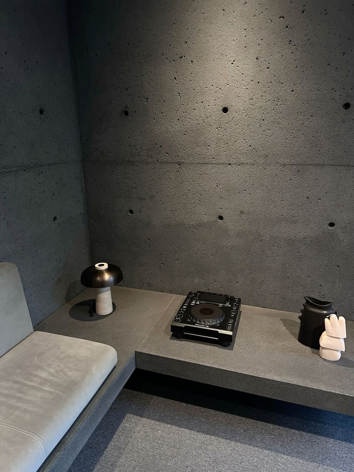 Interior con muros y banco de hormigón arquitectónico